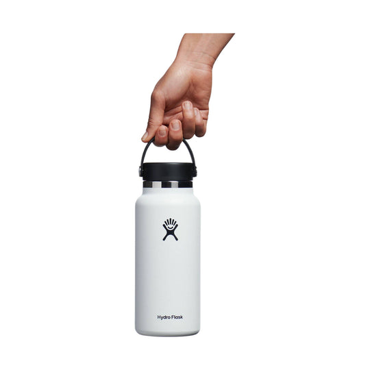 White insulated water bottle with black lid and carry handle, held by a hand