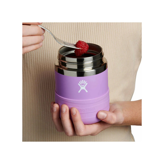 Lavender insulated food jar with a stainless steel rim, shown open and held while a raspberry is lifted from it