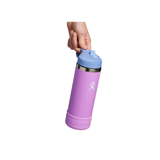 Pink insulated water bottle with a blue straw lid, shown being held by a hand