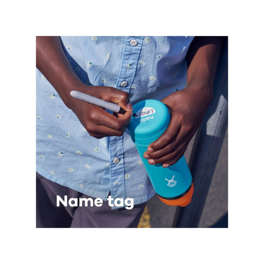 Blue kids water bottle with orange base, held in hand while being labeled with a marker