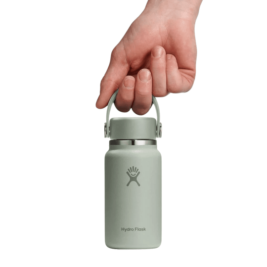 Small sage green insulated water bottle with carry loop and hand gripping the cap