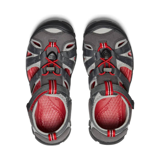 Pair of gray and black closed-toe kids sandals with red bungee laces, shown from above