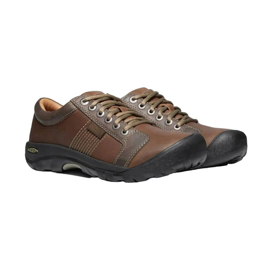 Brown leather lace-up shoes with black rubber soles, shown in a side view
