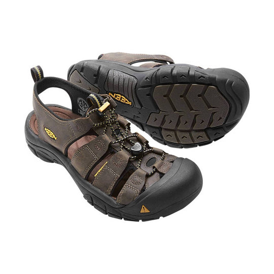 Brown sandals with black soles on a white background
