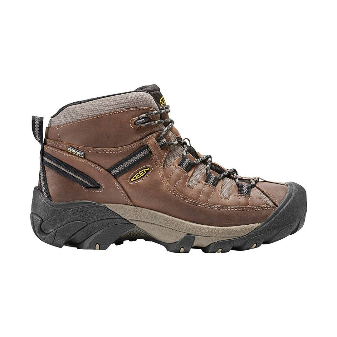 Brown hiking boot with black sole on a white background