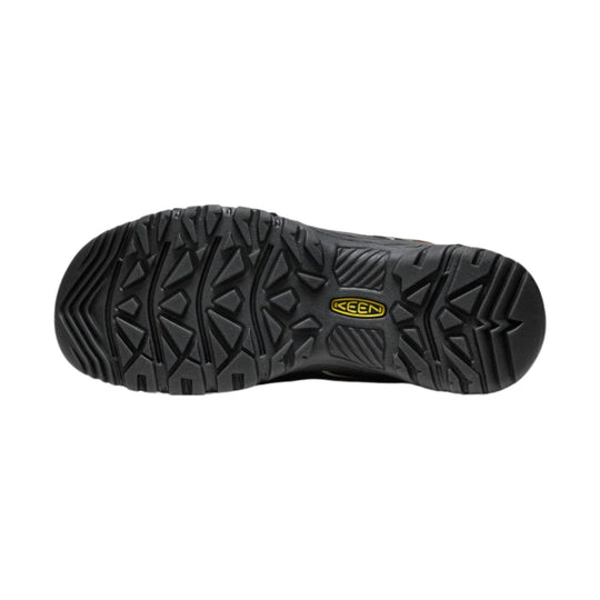 Black hiking shoe outsole with deep tread and a yellow KEEN logo