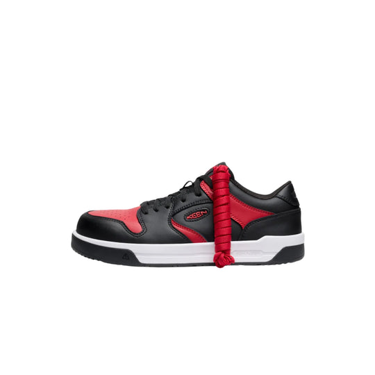 Black and red low-top sneaker with black laces and a white midsole, side view