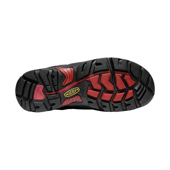 Close-up of a red and black shoe sole with Keen logo on a light gray background