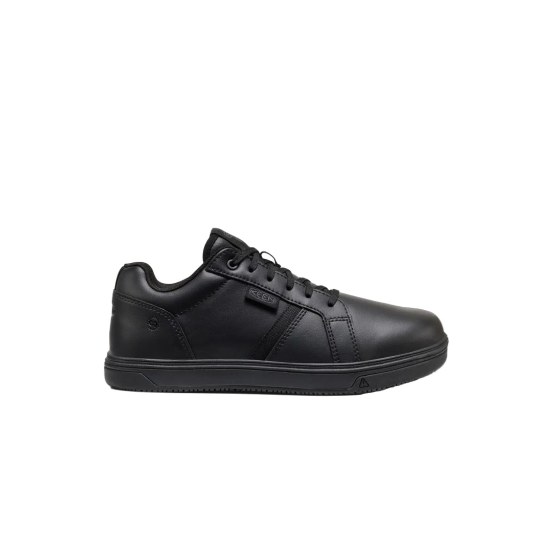 Black low-top work shoe with lace-up front and thick rubber sole, side view