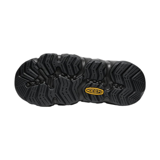 Black shoe outsole with deep tread and a yellow KEEN logo insert