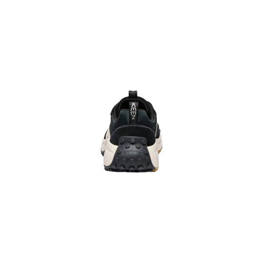 Rear view of a black and white trail shoe with a lugged sole and heel pull tab