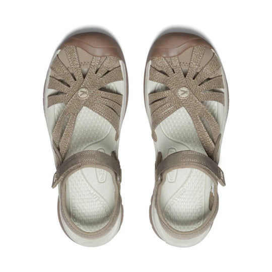 Beige closed-toe sandals with bungee-style crisscross straps and adjustable heel straps