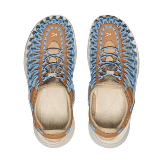 Pair of tan closed-toe hiking sandals with blue bungee lacing, side cutouts, and white soles, top view
