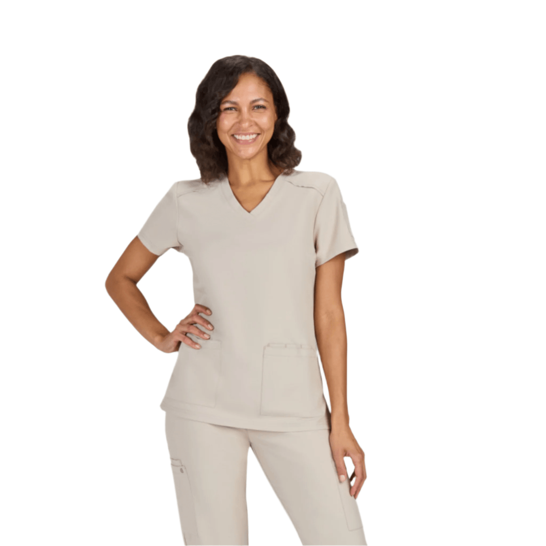 Light beige V-neck scrub top with short sleeves and front pockets, worn with matching scrub pants.