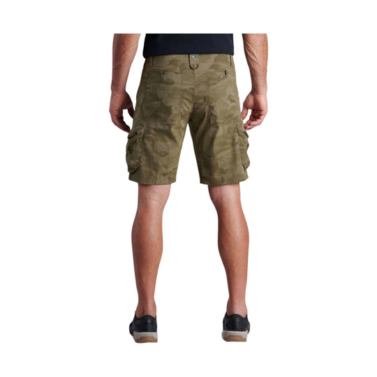 Olive camo cargo shorts shown from the back on a model, with side flap pockets and knee-length hem