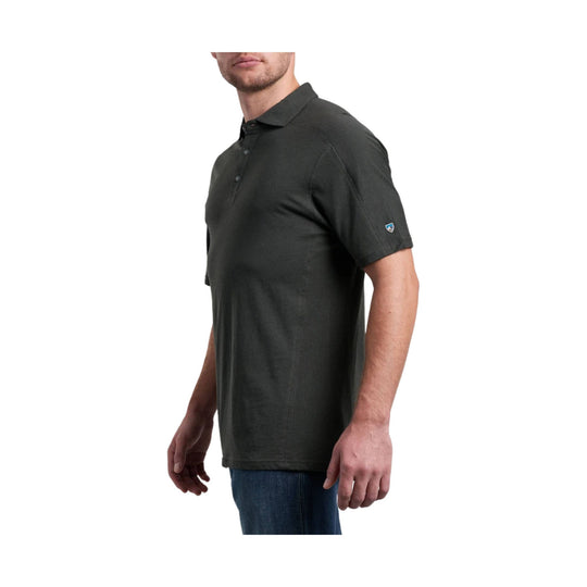 Dark short-sleeve polo shirt with button placket and small sleeve logo, shown on a model in side view