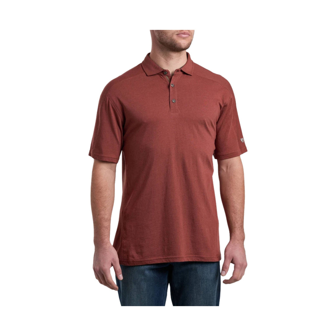 Rust-colored short-sleeve polo shirt with a three-button placket and collar, shown on a male model