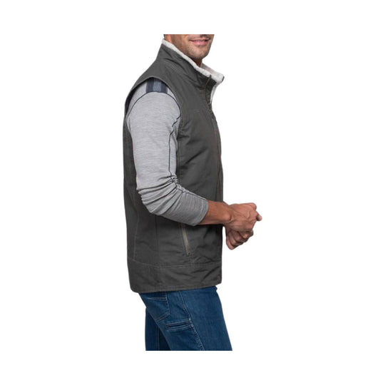 Dark gray sleeveless zip-up vest with a fleece-lined collar, shown over a light gray long-sleeve shirt