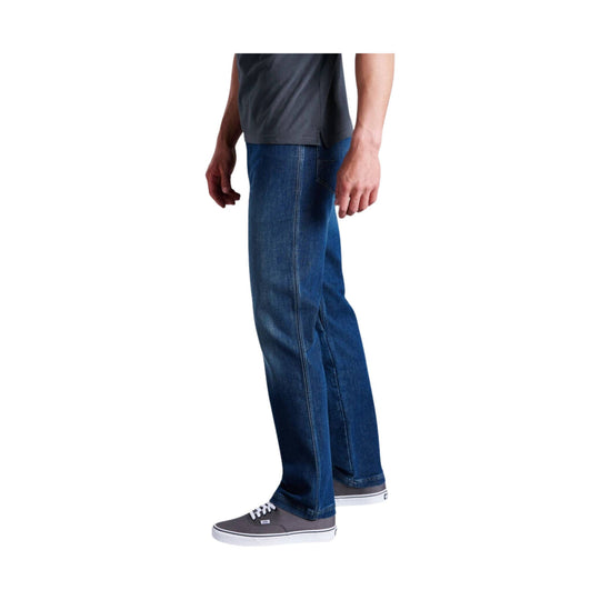 Medium-wash blue straight-leg jeans worn with a dark gray T-shirt and gray low-top sneakers
