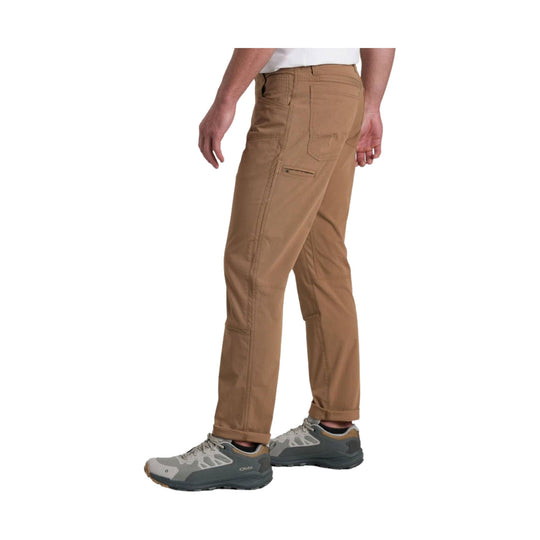 Tan straight-leg pants with cargo pockets, shown on a model from the side