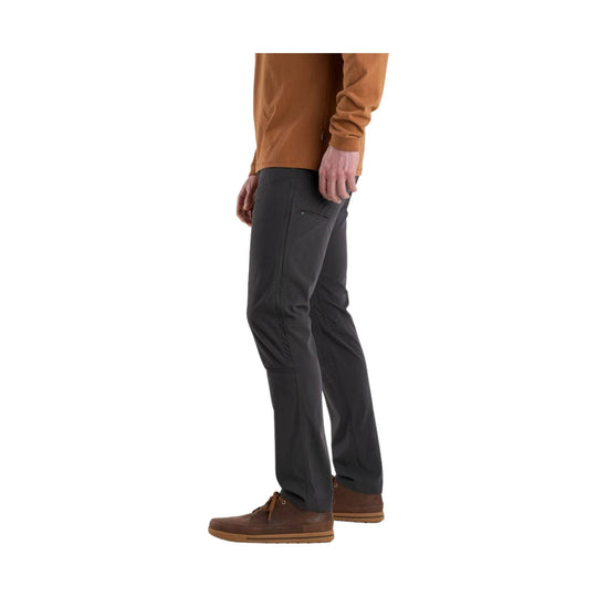 Charcoal hiking pants with a zippered thigh pocket, worn with brown shoes