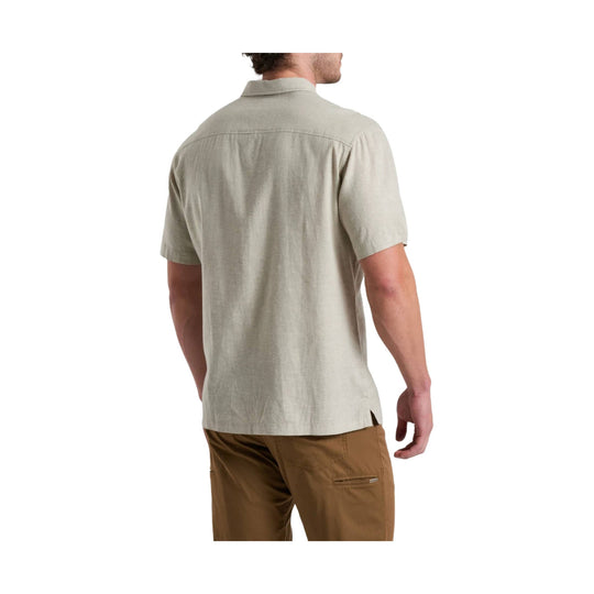 Light beige short-sleeve button-up shirt shown from the back, paired with brown pants