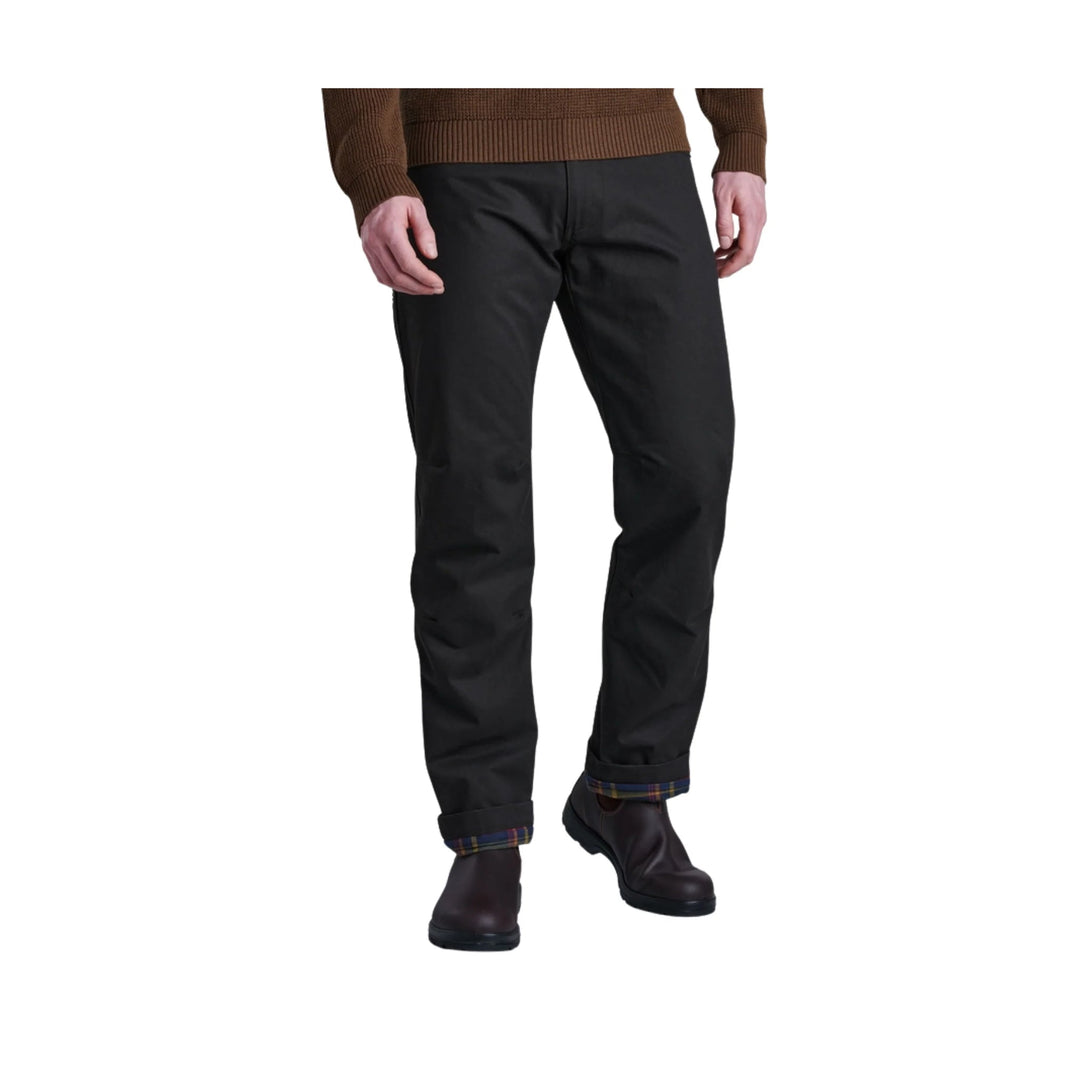Black straight-leg pants on a model, cuffed to show plaid lining, worn with dark ankle boots