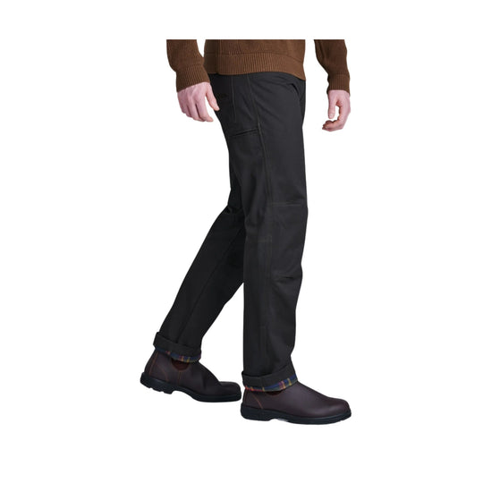 Black straight-leg pants worn with rolled cuffs and dark slip-on shoes