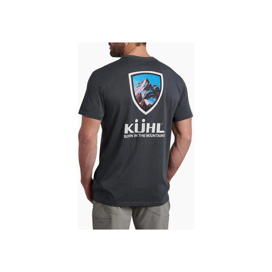 Dark charcoal T-shirt shown from the back with a mountain graphic and the text "KÜHL BORN IN THE MOUNTAINS"
