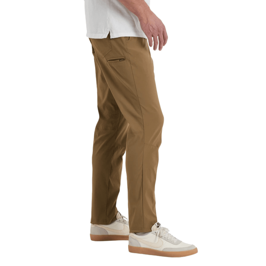 Tan straight-leg pants with side zip pocket, shown on a model with white sneakers