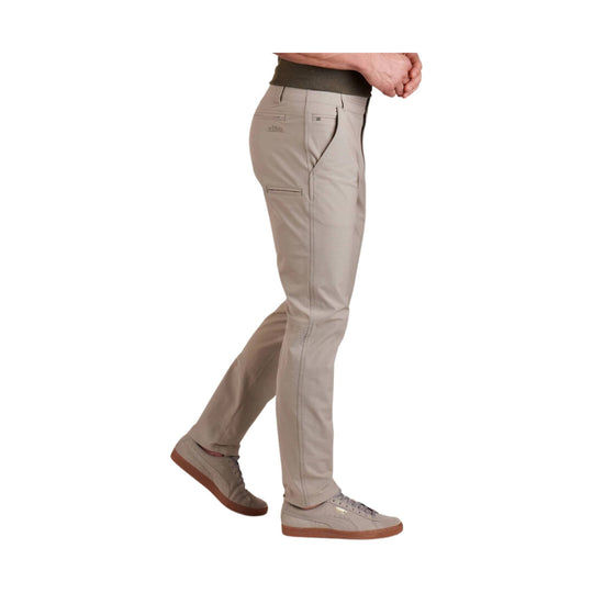 Beige tapered chino pants shown in side view on a model