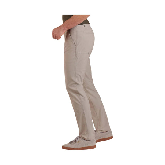 Khaki tapered pants shown in side view with back and side pockets