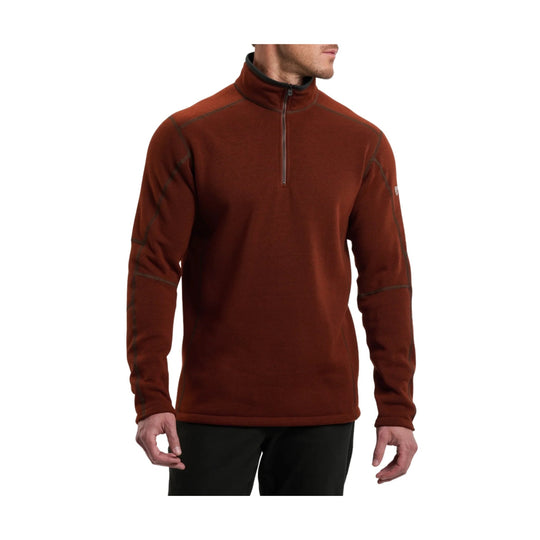 Rust-colored quarter-zip pullover with long sleeves and contrast stitching, shown on a model