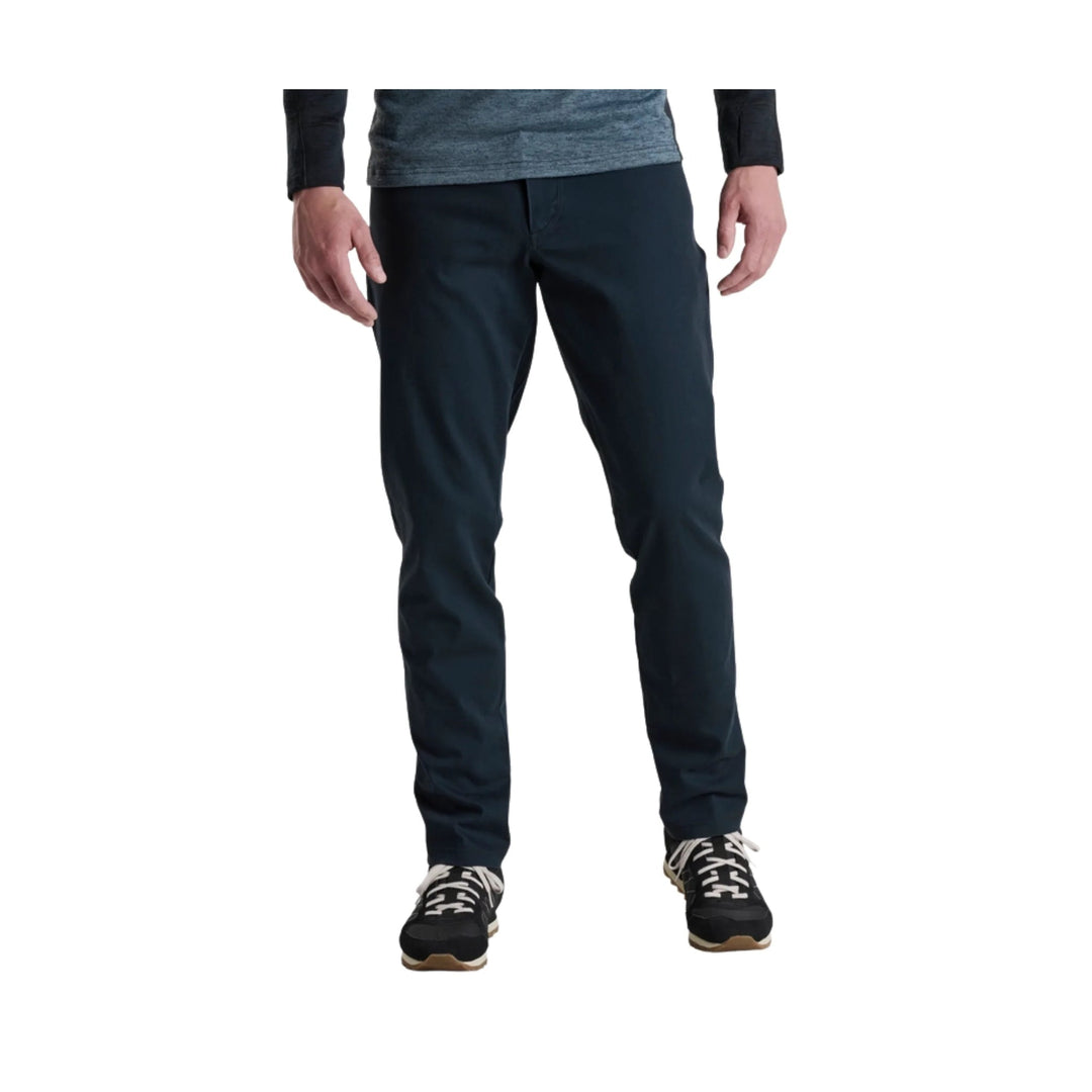 Dark navy tapered pants on a model, shown front view with sneakers