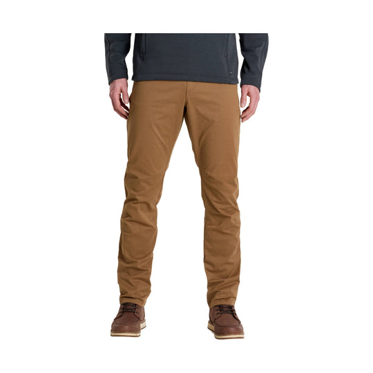 Brown straight-leg pants with a slim fit, shown on a model with dark hiking shoes