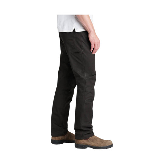 Person wearing brown pants and brown boots on a white background
