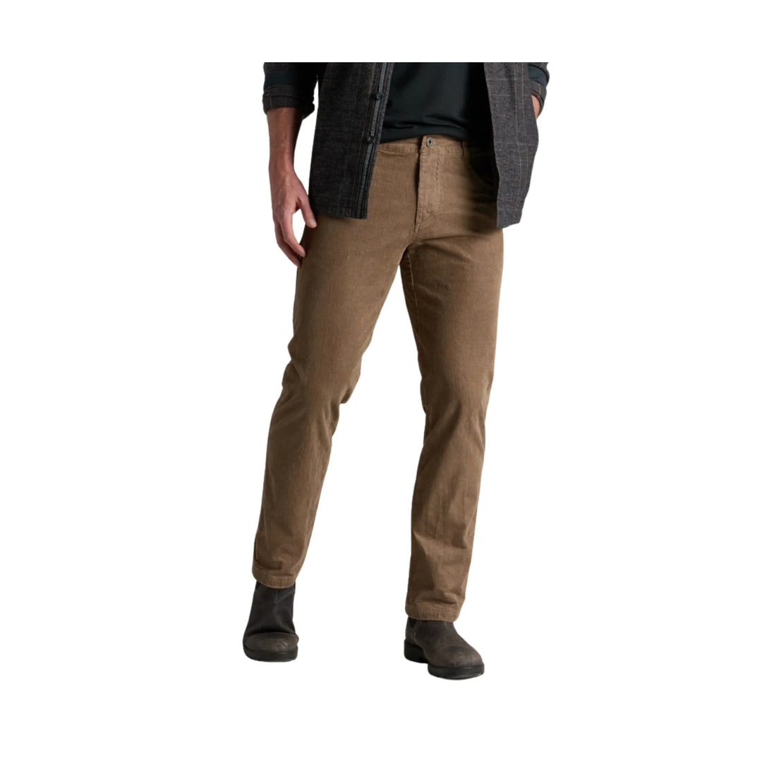 Tan straight-leg pants with a zip fly and front pockets, worn with dark boots