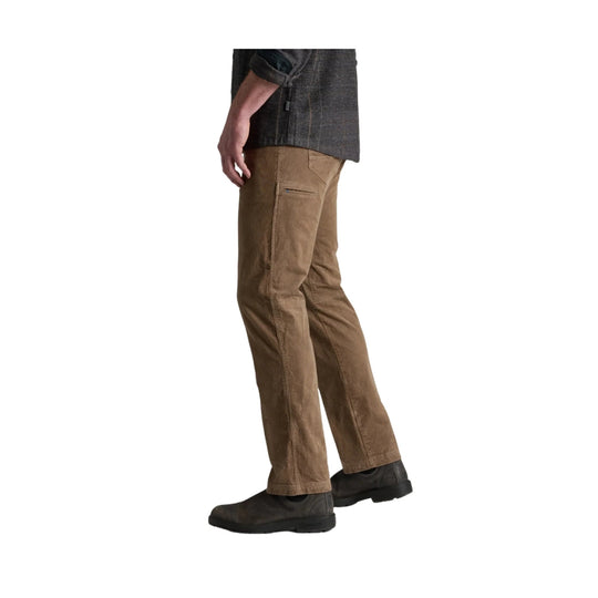 Side view of brown corduroy pants with zip thigh pocket and black shoes