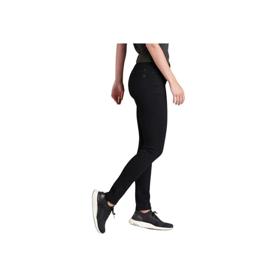 Black skinny pants shown on a model in side view with black sneakers
