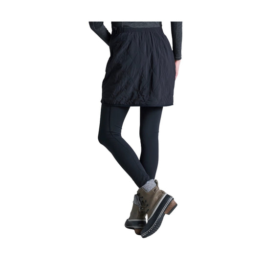 Black quilted skirt over black leggings with brown hiking boots, shown from the back