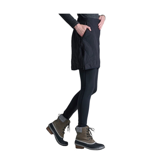 Black quilted skirt worn over black leggings with hiking boots