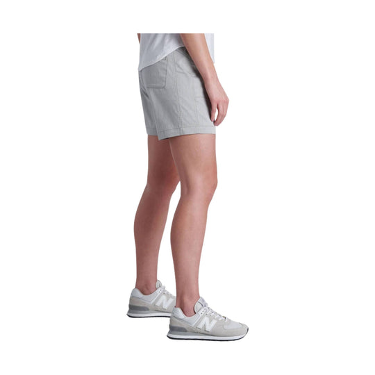 Light gray women’s shorts with back patch pockets, shown on a model with white sneakers
