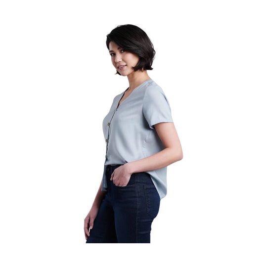 Light blue short-sleeve button-front blouse with a V-neck and dark jeans, shown in side profile