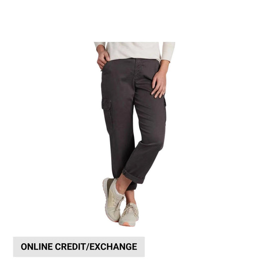 Dark cropped cargo pants with side pockets, rolled cuffs, and beige sneakers