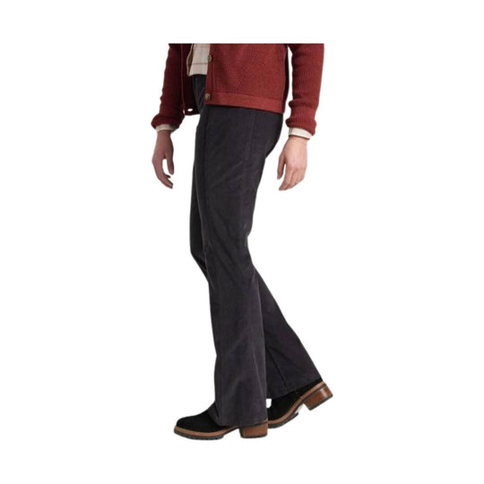 Black corduroy flare pants shown with black platform shoes and a rust cardigan