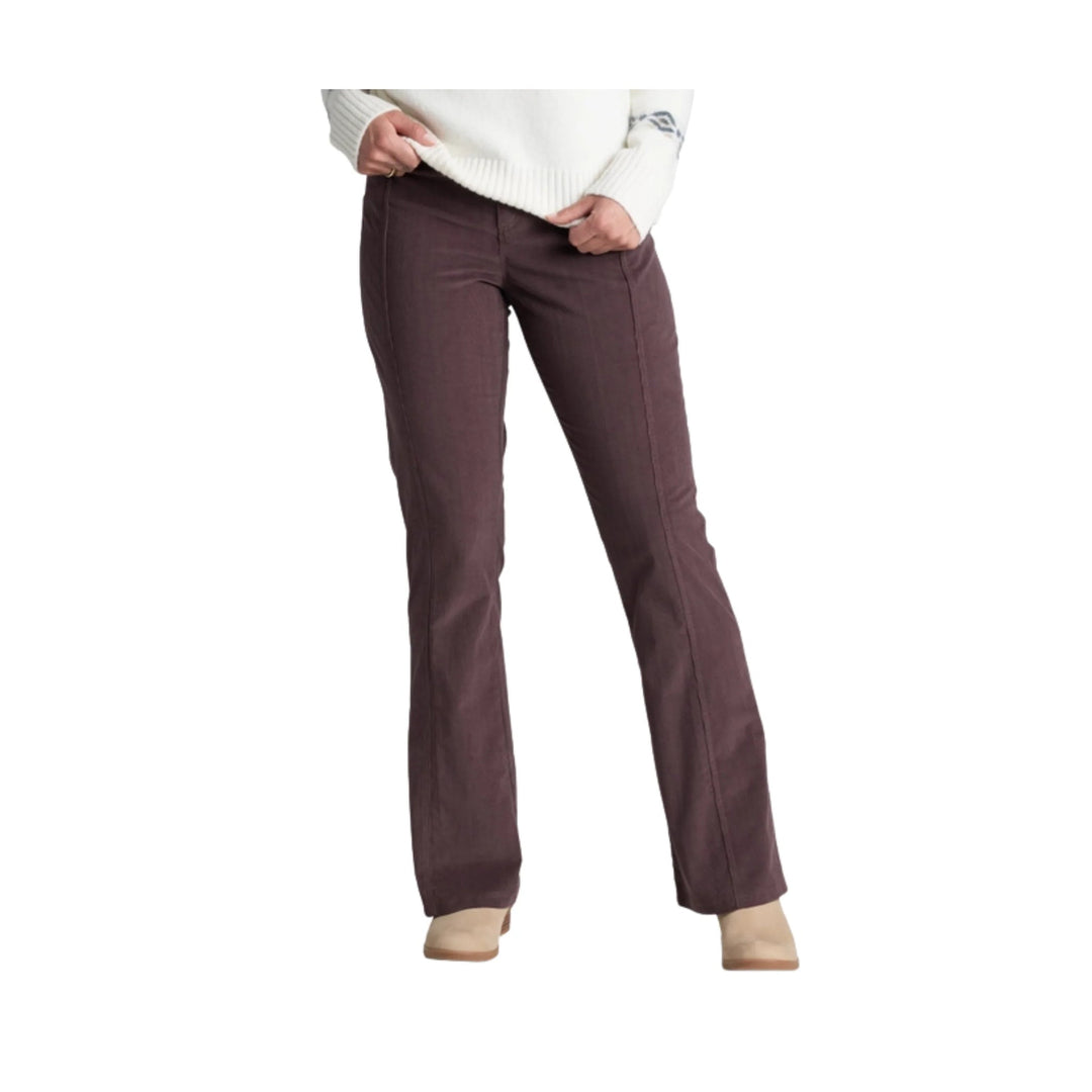 Brown corduroy bootcut pants on a model with a white sweater and tan shoes