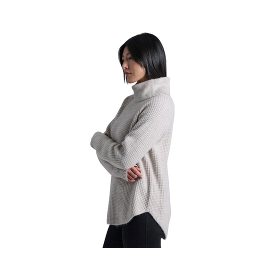 Light gray oversized turtleneck sweater with textured knit and side slits, shown in side profile