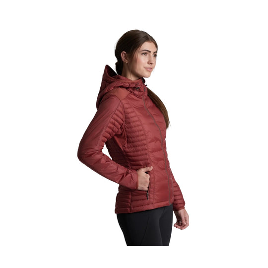 Rust-red hooded puffer jacket on a woman in side view