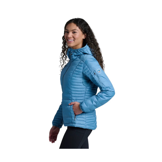 Blue quilted hooded women's jacket with zip pockets, shown in side profile