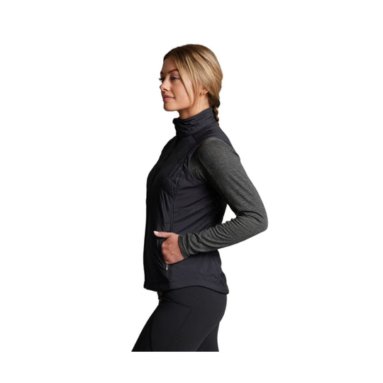Black sleeveless zip-front vest over a gray long-sleeve top, shown in side profile